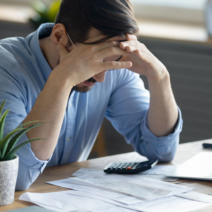 Rengøringsvirksomhedsejer der gennemgår regninger og papirarbejde, som viser stress og administration i hverdagen.